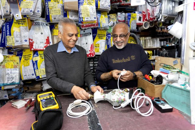 Two people repairing a lamp in a repair shop