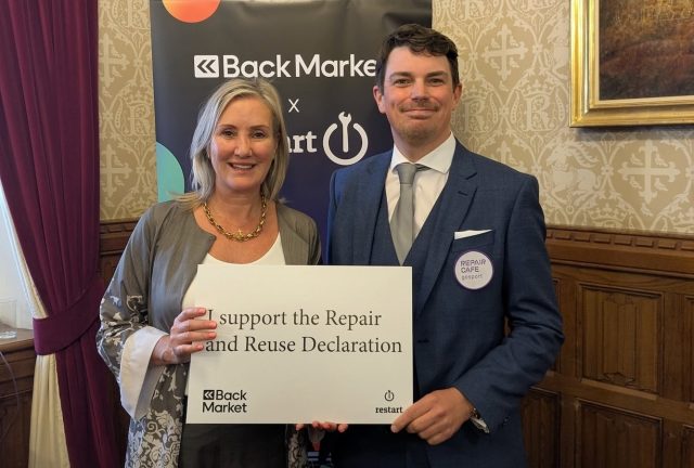 A photo of two people wearing formal clothes holding a sign that reads 'I support the Repair and Reuse Declaration'